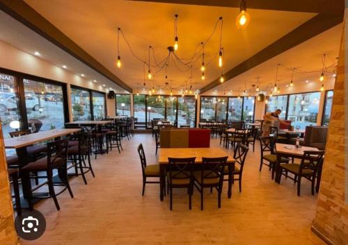 a restaurant with tables and chairs and windows at Milmari resort N12 in Kopaonik