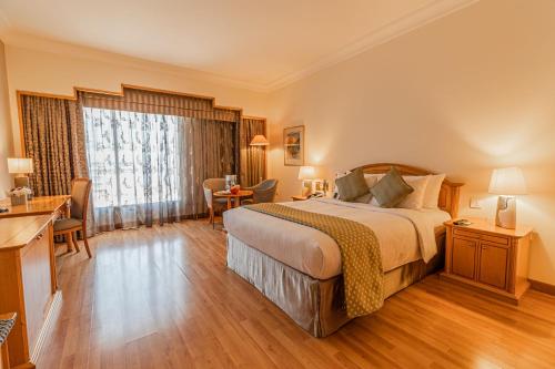 a hotel room with a bed and a desk at Millennium Downtown in Abu Dhabi