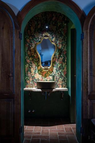 a bathroom with a sink and a mirror on a wall at Fattoria Fibbiano in Terricciola
