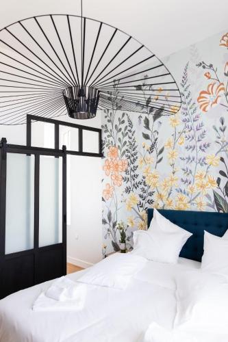 - une chambre avec un lit et un mur fleuri dans l'établissement Château Martinho, à Listrac-Médoc