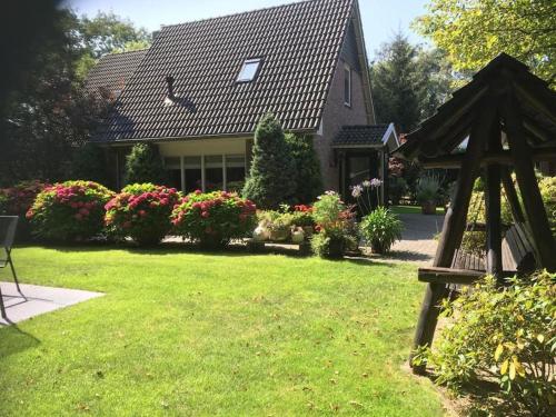a house with a garden and a gazebo at Wendrik Hoeve Bed & Stables in Emst