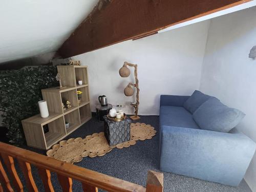 a living room with a blue couch and a table at Duplex 85m2 au coeur de la nature à Montpezat-sous-Bauzon in Montpezat-sous-Bauzon