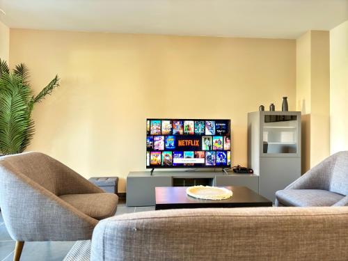 - un salon avec deux chaises et une télévision à écran plat dans l'établissement Vista Marina By SCLS Locations, à Mandelieu-la-Napoule