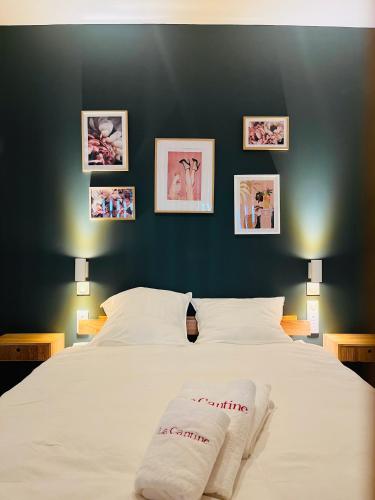 - une chambre dotée d'un grand lit blanc avec des photos sur le mur dans l'établissement Biarritz Beaurivage - Magnifique T1 bis, à Biarritz