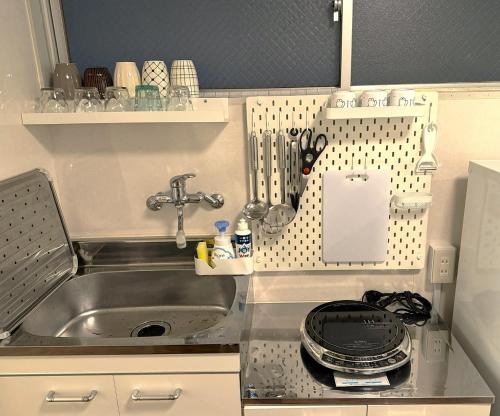 a small kitchen with a sink and a counter top at Elena Shinsaibashi Stay in Osaka