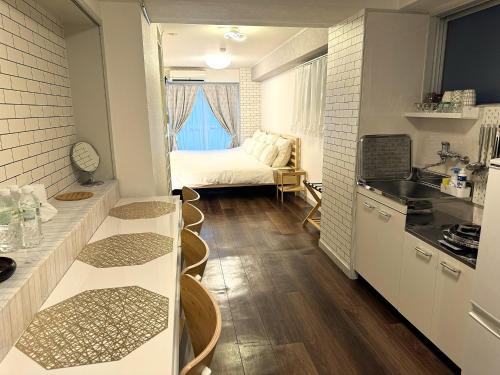 a small room with a kitchen and a bedroom at Elena Shinsaibashi Stay in Osaka