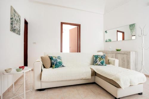 a white living room with a couch and a table at Chez Dione in Siracusa