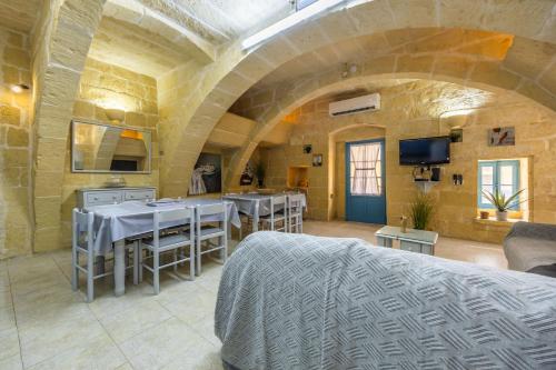 a room with tables and chairs in a stone building at Room 8 - Couples room x 2 by Solea in Għarb