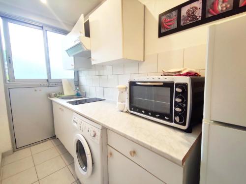 a kitchen with a microwave on a counter at Grand Studio avec piscine à Mandelieu in Mandelieu-la-Napoule