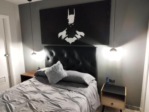 a bedroom with a bed with a batman painting on the wall at Apartamento de lujo en Valencia 2 in Valencia