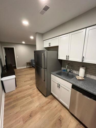 a kitchen with white cabinets and a stainless steel refrigerator at Aksarben Area 2 BD-2 BA by UNO in Omaha