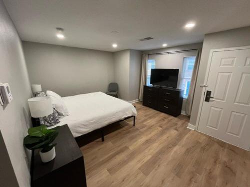 a bedroom with a white bed and a television at Aksarben Area 2 BD-2 BA by UNO in Omaha