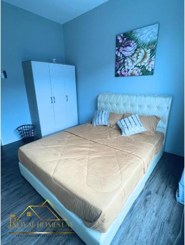 a bedroom with a large bed with a blue wall at Royal Homestay Palm Garden in Lahad Datu