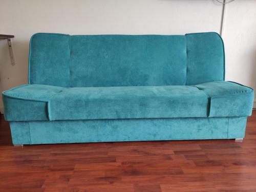 a blue couch sitting in a living room at Grand Studio avec piscine à Mandelieu in Mandelieu-la-Napoule