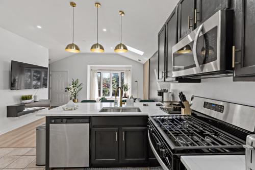 a kitchen with black cabinets and white counter tops at The Haven, Great Location near Downtown, Medical District and United Center in Chicago