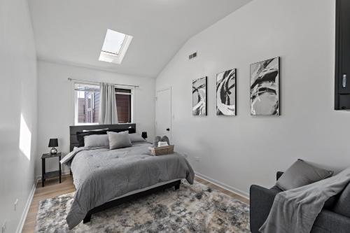 a white bedroom with a bed and a couch at The Haven, Great Location near Downtown, Medical District and United Center in Chicago