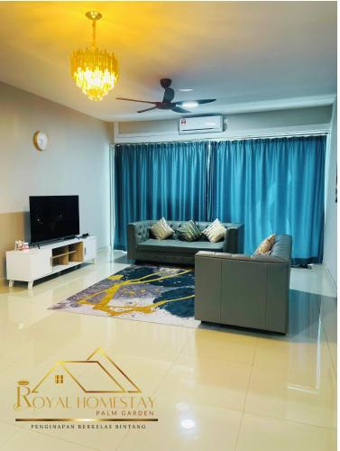 a living room with a couch and a tv at Royal Homestay Palm Garden in Lahad Datu