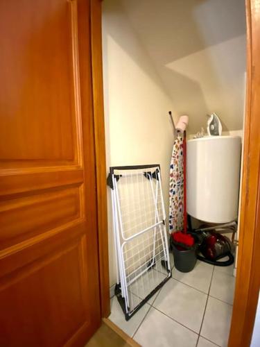 a hallway with a door and a white tile floor at La Belle Cuvée - Plein centre-ville Chablis in Chablis