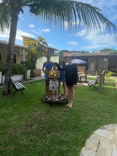 a family standing on a skateboard in a yard at Pousada Sapê in Praia do Frances
