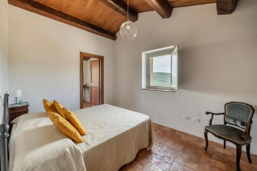 a bedroom with a bed with a chair and a window at Banditella in Orvieto