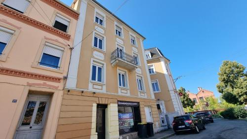un grand bâtiment avec une voiture garée devant dans l'établissement Résidence Évasion & Élégance - Mulhouse, à Mulhouse