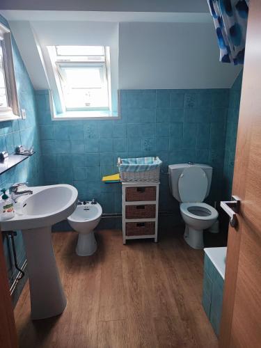 a bathroom with a sink and a toilet and a window at Piso céntrico cerca de la playa in Cedeira