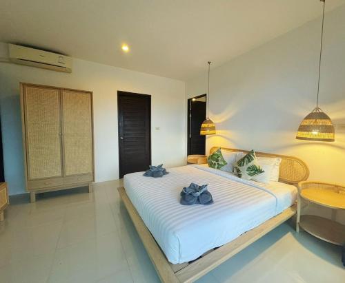 a bedroom with a large white bed and a table at High Life Villas in Salad Beach