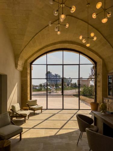 a large room with chairs and a large window at Masseria Donna Menga - The Leading Hotels of the World in Torre Lapillo