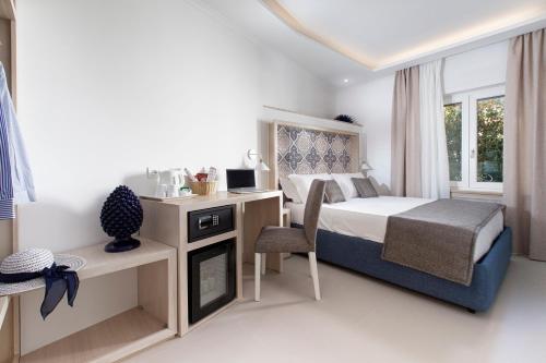 a bedroom with a bed and a desk with a chair at Camalù Sorrento in Sorrento