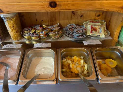 a display of food in trays on a shelf at Hotel Diffuso Il Portichetto sulla collina a Vezio Perledo in Perledo