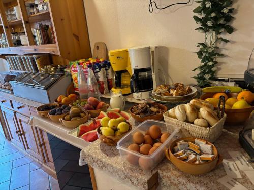 a kitchen counter with many baskets of fruits and vegetables at Hotel Diffuso Il Portichetto sulla collina a Vezio Perledo in Perledo