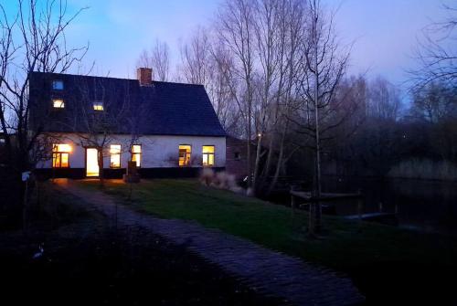a house with its lights on at night at City Farmhouse and studio in Roeselare