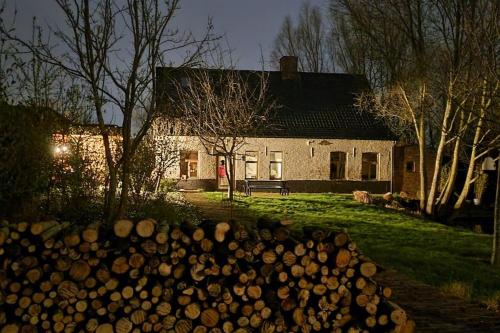 a pile of logs in front of a house at City Farmhouse and studio in Roeselare