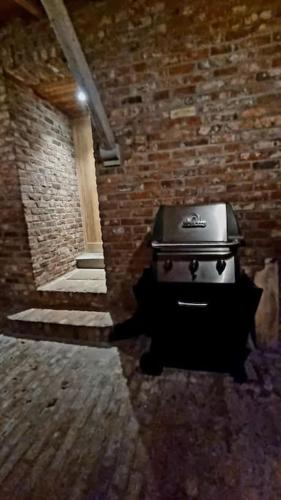 a stove in a brick room with a brick wall at City Farmhouse and studio in Roeselare