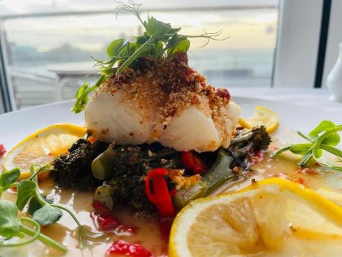 a plate of food with a piece of chicken with vegetables at The Harbour House Sea front Hotel in Portpatrick