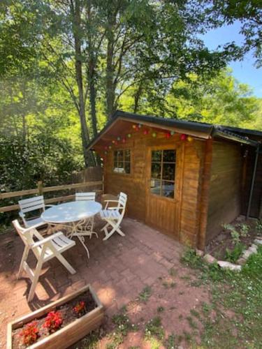 une terrasse avec une table et des chaises ainsi qu'une cabine dans l'établissement Chalet Vallespir Au fil de l'eau Immersion nature, à Lamanère