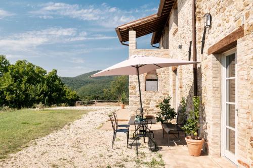 a table and chairs with an umbrella outside of a building at Banditella in Orvieto