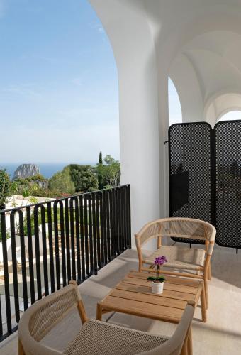 a balcony with a table and chairs and the ocean at Villa Certosa in Capri