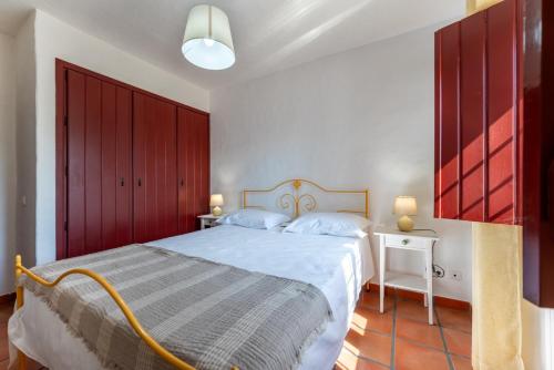 a bedroom with a large bed and red cabinets at Monte do Sobreiro in Vimieiro
