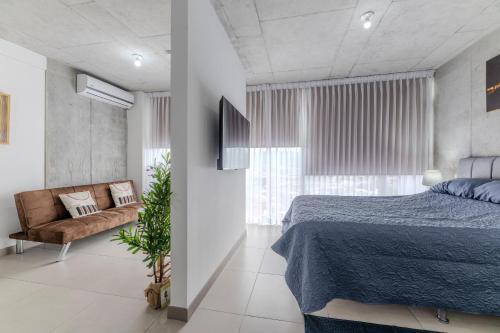 a bedroom with a blue bed and a couch at Skyline iFreses, 22nd floor! AC, TV and Pool in Guayabos