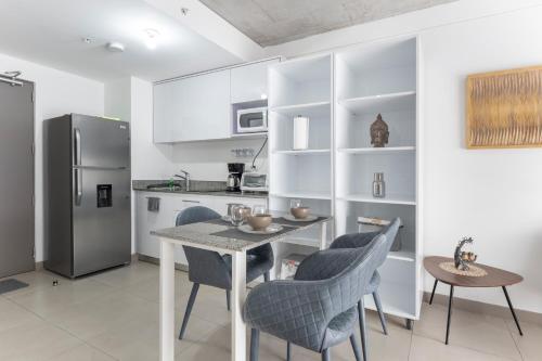 a kitchen with a table and chairs and a refrigerator at Skyline iFreses, 22nd floor! AC, TV and Pool in Guayabos