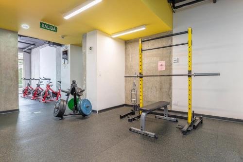 a gym with bikes and weights in a room at Skyline iFreses, 22nd floor! AC, TV and Pool in Guayabos