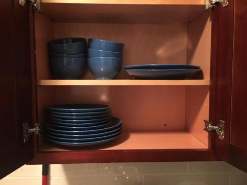 a cupboard with blue bowls and plates in it at Chrystie Street Apartments in New York