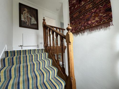 a room with a staircase with a striped couch at Castle Rock, Crail in Crail