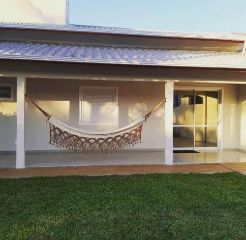 eine Hängematte, die an der Seite eines Hauses hängt in der Unterkunft Praia do Sonho in Palhoça