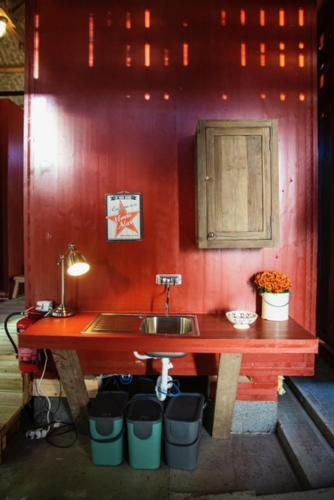 a kitchen with a sink and a red wall at Hyttelåven på Furuholmen in Sarpsborg