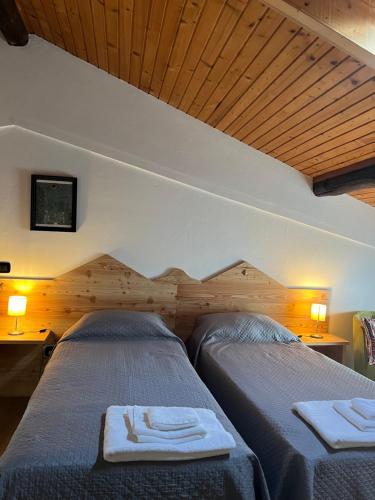 due letti in una stanza con soffitti in legno di bed an breakfast Aurora a Trento