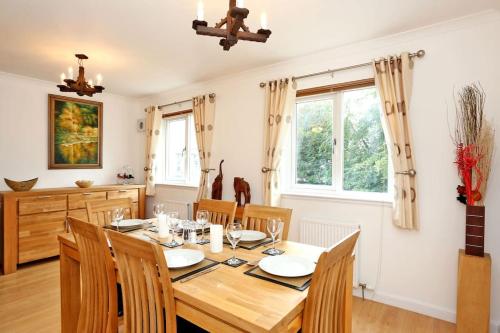 a dining room with a wooden table and chairs at Spacious 4 bedroom Townhouse near Scenic Beach & City Centre in Aberdeen