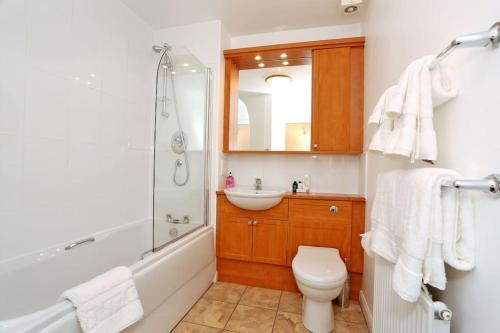 a bathroom with a toilet and a sink and a shower at Spacious 4 bedroom Townhouse near Scenic Beach & City Centre in Aberdeen