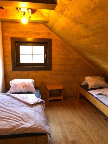 a attic room with two beds and a window at Chalupa Grúnik in Zázrivá